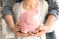 Couple holding piggy bank, closeup. Money savings concept