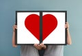 Couple holding red heart in picture frames. Royalty Free Stock Photo