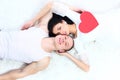 Couple holding red heart together lying in a bed Royalty Free Stock Photo