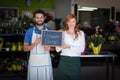 Couple holding slate with flower shop sign Royalty Free Stock Photo