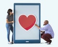 Couple holding tablet together heart icon