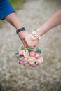 Couple Holds Hand with Wedding Flower Bouquet