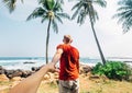 Couple holds for hands and go to ocean surf line. Together travel concept