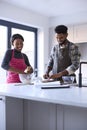 Couple At Home Baking Cake Together In Kitchen 