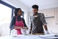 Couple At Home Baking Cake Together In Kitchen 