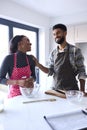 Couple At Home Baking Cake Together In Kitchen 