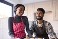 Couple At Home Baking Cookies Together In Kitchen 