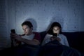 Couple at home in bed late at night using mobile phone in relationship communication problem