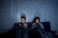 Couple at home in bed late at night using mobile phone in relationship communication problem Royalty Free Stock Photo