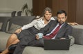 Couple at home in formalware with man working and woman watching