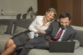 Couple at home in formalware with man working and woman watching