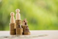 Couple and home model on rows of rising coins, US dollar bags on a table. Concept house or building or land value, property tax, Royalty Free Stock Photo