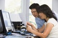 Couple in home office with computer and paperwork Royalty Free Stock Photo