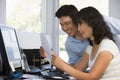Couple in home office with computer and paperwork Royalty Free Stock Photo