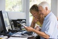 Couple in home office with computer and paperwork Royalty Free Stock Photo