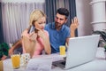 Couple at home paying bills with laptop and credit card Royalty Free Stock Photo