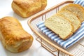 A couple of homemade white bread on a cooling rack with a cloth on white table Royalty Free Stock Photo