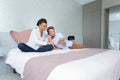 couple in hotel room reading room service menu in bed Royalty Free Stock Photo