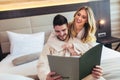 Couple in hotel room reading room service menu together Royalty Free Stock Photo