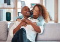 Couple, hug and laughing on sofa in home living room, bonding, relaxing and having fun. Interracial, love and funny