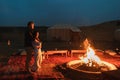 Couple hug in love near big campfire. Romantic night in glamping desert camp