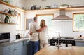 Couple hug, morning coffee and senior people having breakfast in the kitchen while looking at outdoor nature. Elderly Royalty Free Stock Photo