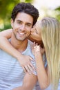 Couple, hug and woman kiss man in park with smile, love and commitment in healthy relationship. People on date outdoor Royalty Free Stock Photo