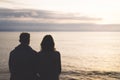 Couple hugging on the beach on background ocean sunrise, silhouette two romantic people cuddling and looking on rear view evening Royalty Free Stock Photo