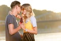 couple hugging and drinking beverage with two plastic straws from one bottle on river beach Royalty Free Stock Photo