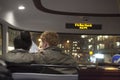 The couple, hugging, sitting on the bus in the front seat