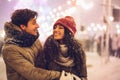 Couple Hugging Standing On A Street Decorated With Winter Lights