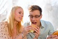 Couple is hungry and eating a burger at break Royalty Free Stock Photo