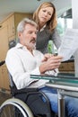 Couple With Husband In Wheelchair Reading Letter