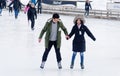 A couple ice skating on an outdoor rink in Montreal