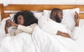 Couple ignoring each other after argue, using smartphones in bed Royalty Free Stock Photo