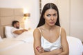 Couple ignoring each other in bed, Unhappy young heterosexual couple in bedroom. Sad Woman Sitting At The Edge Of Bed In Front Of Royalty Free Stock Photo