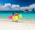 Couple with inflatable rafts looking at seaplane on beach