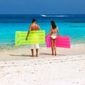 Couple with inflatable rafts on a tropical beach