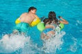 Couple in inflatable rings at swimming pool