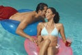 Couple In Inflatable Rings Whispering At Pool