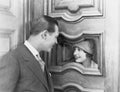 Couple interacting through hole in door