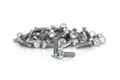 A couple of isolated galvanized industrial steel screws in front of blurt pile on white background Royalty Free Stock Photo