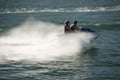 Couple on jet ski on blue-green water Royalty Free Stock Photo