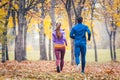 Couple jogging in colorful foliage, seen from behind