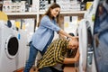 Couple jokes with washing machine in store