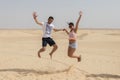 Couple jumping In the air in Sahara Desert, Tunisia, Africa