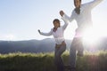 Couple Jumping While Holding Hands In Park Royalty Free Stock Photo