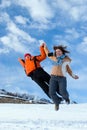 Couple jumping over blue sky in winter mountains Royalty Free Stock Photo