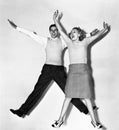 Couple jumping with their arms outstretched