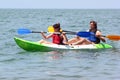Couple of kayakers rowing in sea water Royalty Free Stock Photo